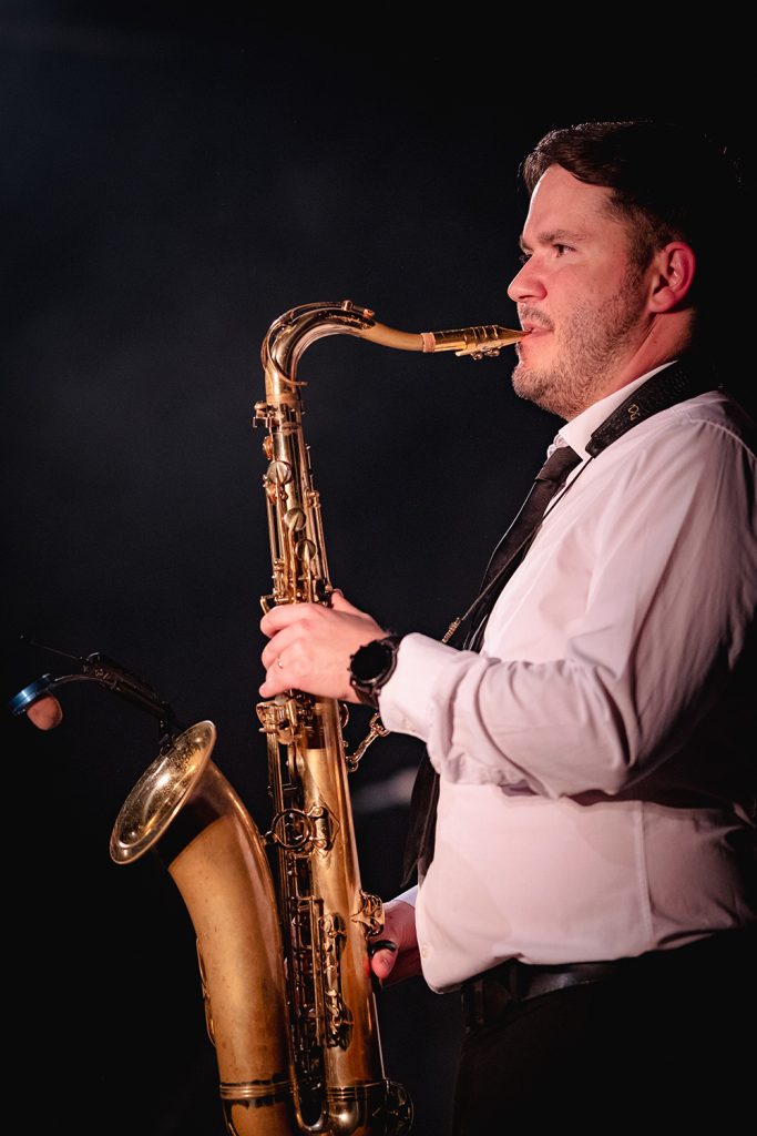 A saxophone player on a dark stage