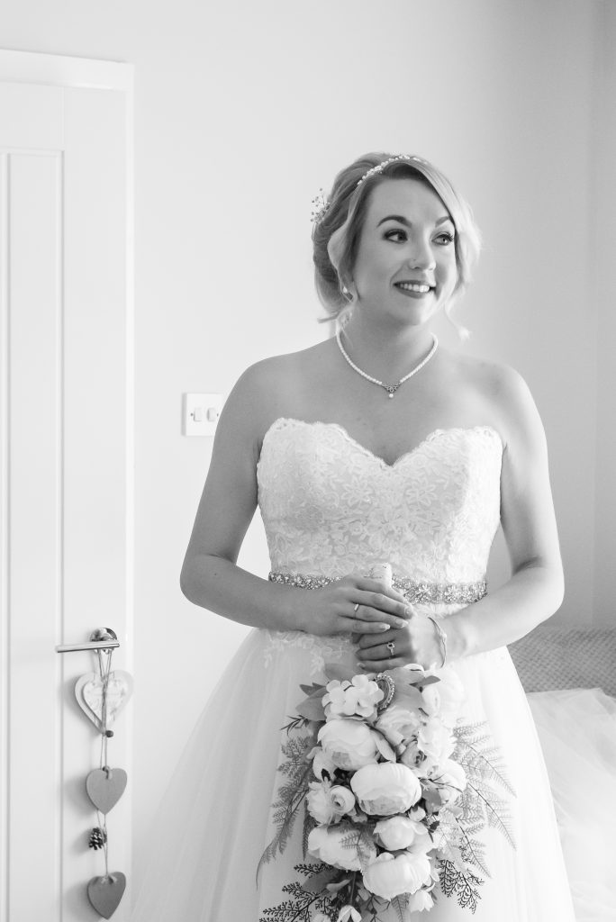 Black and white photo of a bride in her wedding dress.