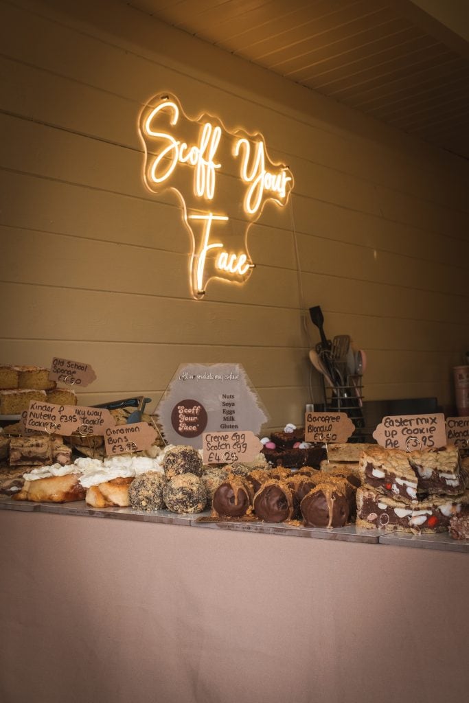 A table full of pastries with a neon sign on it.