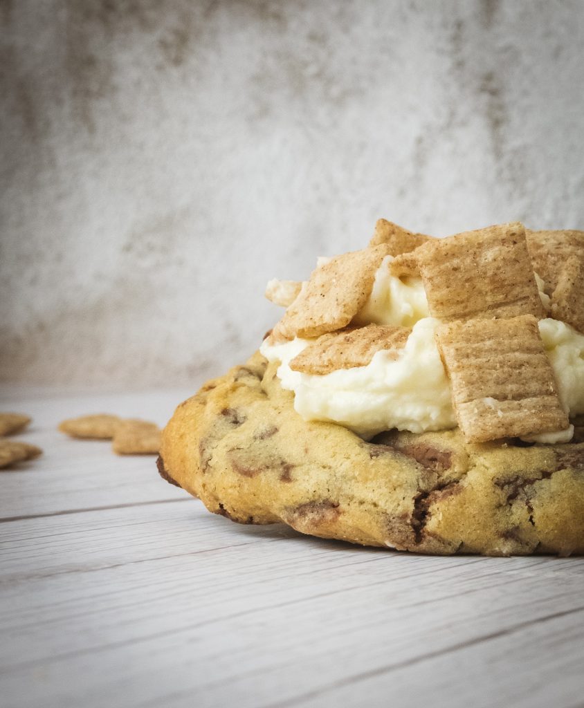 A cookie topped with cream and graham crackers.