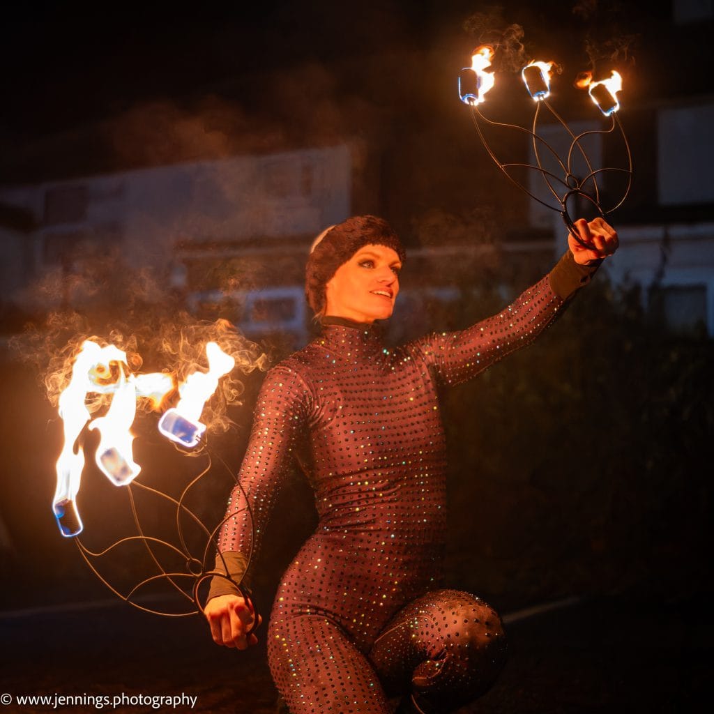A woman is holding two fire torches.