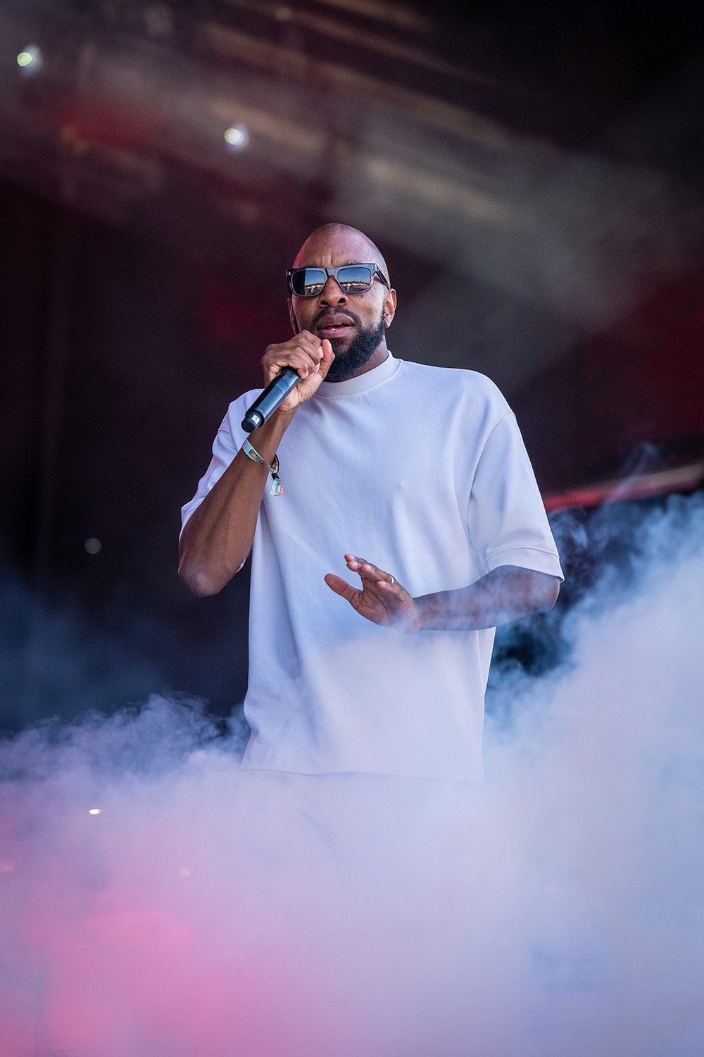 A man in a white shirt singing into a microphone.