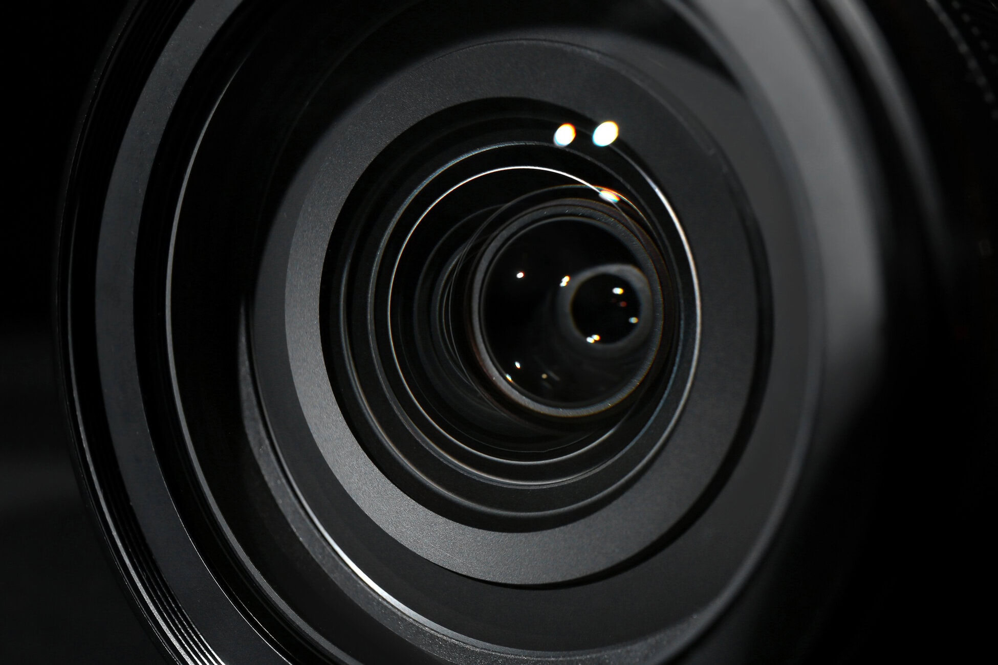 Close-up view of a camera lens, showing concentric rings, reflections, and intricate glass elements. Wedding Photo taken by Jennings Photography