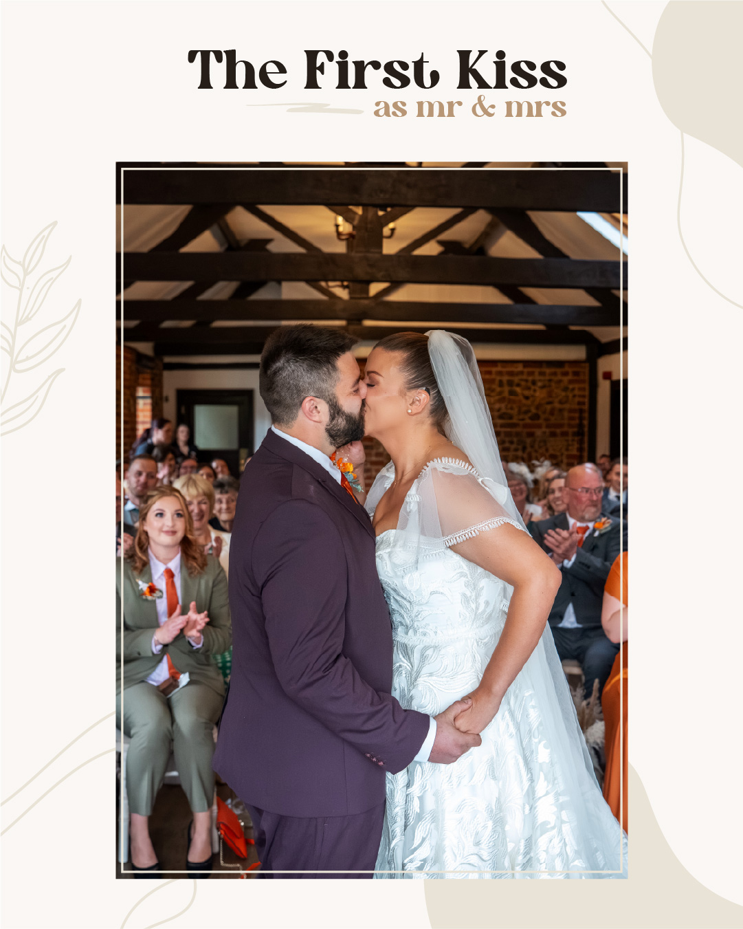 A bride and groom share their first kiss as a married couple in front of seated wedding guests inside a decorated venue. Wedding Photo taken by Jennings Photography